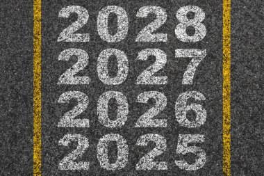 Yeni yıl 2025 'ten 2027' ye kadar asfalt yolun ortasında yeni yıl konsepti olarak yazıldı..