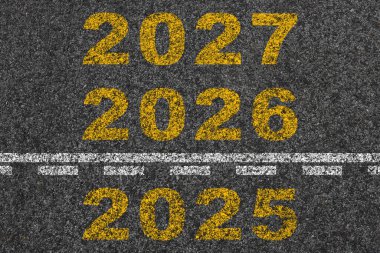 Yeni yıl 2025 'ten 2027' ye kadar asfalt yolun ortasında yeni yıl konsepti olarak yazıldı..
