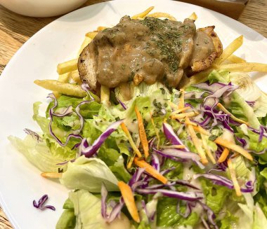 Ekstra ızgara tavuk bifteği salatası, kremalı mantar sosu ve kızarmış patates kızartması.