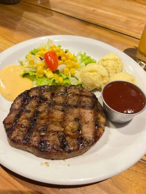 Ağzını sulandıran bir bifteğin tadını çıkar, canlı salata ve kremalı patates püresiyle tamamlanmış olsun. Restoran promosyonları ve mutfak içeriği oluşturulması için mükemmel..