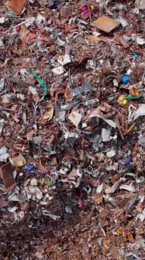 Dikey video. Metal plastik plastik parçaları ve ahşap kaplı zemin pürüzlü mozaik gibi. Sivri uçlar ışığı yakalar ve küçük vidalar cıvatalar folyoyla parlatılır geri dönüşüm sırasında.