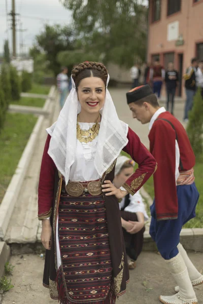 Flicka i serbiska folkdräkt till folk bor och ler — Stockfoto