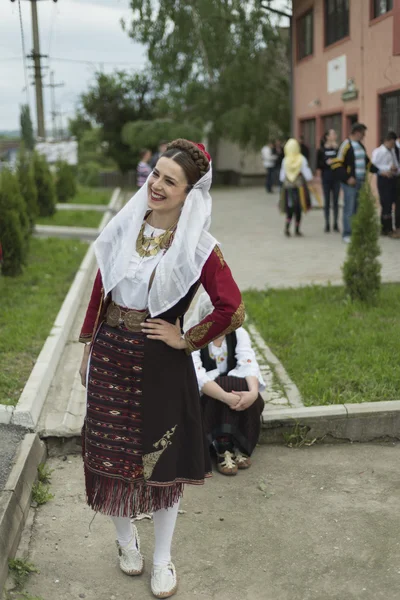 Flicka i serbiska folkdräkt till folk bor och ler — Stockfoto