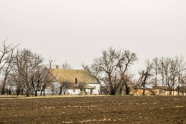 Panorama of prepared arable land with the Farmer's house in the spring