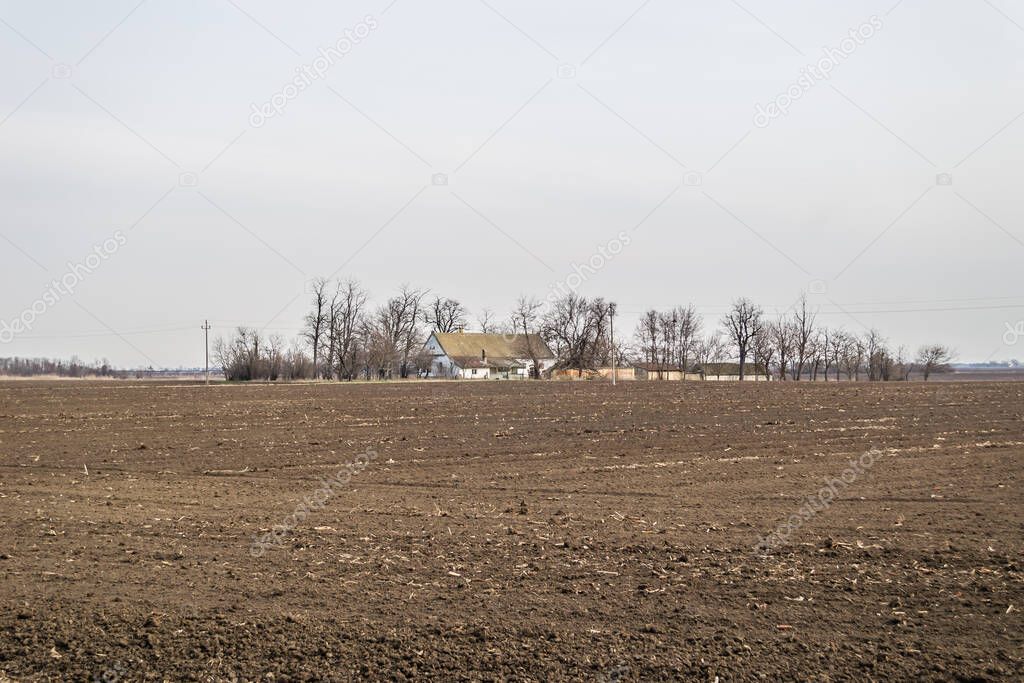 Panorama of prepared arable land with the Farmer's house in the spring
