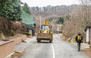 Novi Sad, Sırbistan - Şubat 05. 2020: Çalışan makine JCB JS 220 NLC 'yi izledi. Sırbistan 'ın Novi Sad kenti yakınlarındaki Fruska Gora Dağı' nın zirvesine çıkan ana kırsal yolda çalışan bir makine.. 