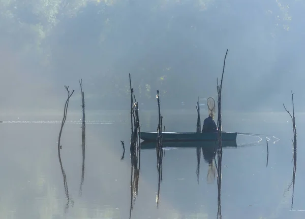 Novi Sad, Serbia - October 22, 2015: A small natural lake near the city of Novi Sad. Wooden fishing boats moored on the shores of the lake, illuminated by the first morning sun.