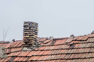 Evin çatısındaki eski harap tuğla baca..