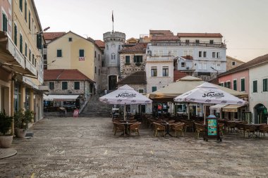 Herceg Novi, Karadağ - 23 Ağustos 2021: Eski evlerle çevrili küçük saat kulesiyle eski kasaba kapısı