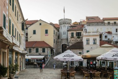 Herceg Novi, Karadağ - 23 Ağustos 2021: Eski evlerle çevrili küçük saat kulesiyle eski kasaba kapısı