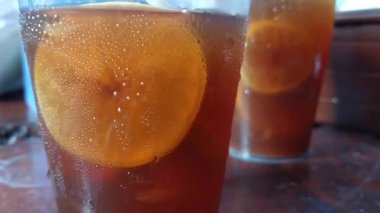 Cam bardakta limonlu bitki çayı demleyip karıştırmak. Lezzetli ve aromatik çay gecenin bir yarısı mutfakta..