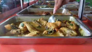 Endonezya 'daki tipik bir Cava Nasi Tegal tezgahında çeşitli yemekler cam bir vitrinde servis edilir. Müşterilere servis yapan bir satıcının sipariş verdiği mezeleri yakın çekim görüntüsü..