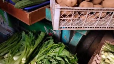 Endonezya 'daki geleneksel pazarda çeşitli sebzeler satışa hazır. Sabah güneşi bazılarını aydınlatıyor, güzel bir atmosfer yaratıyor, küçük iş hareketlerinin ruhunu.