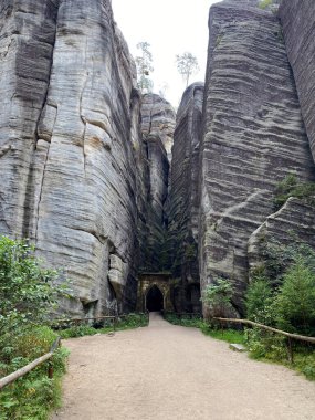 Adrspach Teplice 'nin devasa kumtaşı duvarları, Çek Cumhuriyeti' nde gizemli bir kaya labirentine açılan taş kemerli dar bir geçit oluşturuyor..