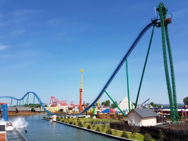 Zator 'daki Energylandia çekimlerinin canlı bir görüntüsü: yükselen hız trenleri, bir su sıçraması alçalması, ve parlak mavi gökyüzü altında sayısız gezinti.