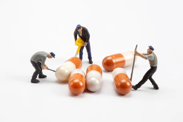 Miniaturmenschen - Arbeiter bewegen Kapseln — Stockfoto