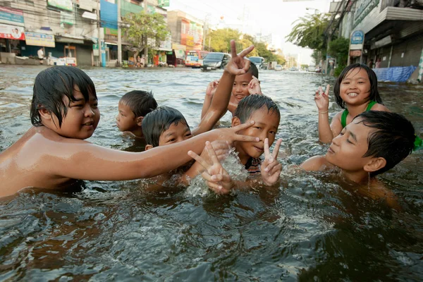 As crianças gostam de ruas inundadas para tomar banho com grandes riscos para a saúde . — Fotografia de Stock
