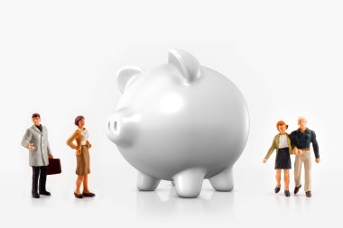 Miniature people in front a piggy bank clipart