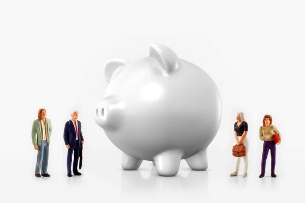 Miniature people in front a piggy bank — Stock Photo, Image