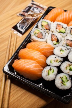 Suşi ve maki plastik tepside satılıyor, yiyecekler alınıyor..