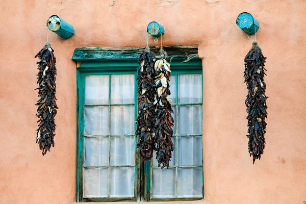 Chillies gebruikt als decoraties van een raam in een gebouw van Taos , — Stockfoto