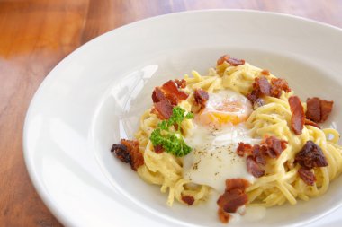 Spagetti Carbonara gevrek domuz pastırması ve yumurta beyaz plaka üzerinde