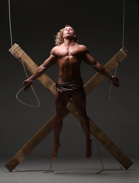 Sexual naked man, muscular, hands tied rope to wooden beams — Stock Photo, Image