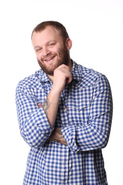 Smiling young man with a beard in plaid shirt looking at camera