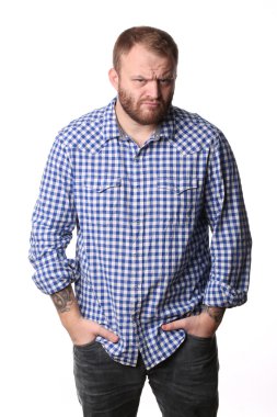 Serious man with a beard, his hands in pocket