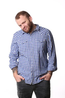 Serious man with a beard, his hands in pocket