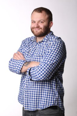 Smiling man with beard standing arms crossed looking at camera