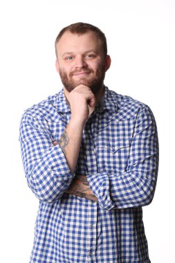 Smiling young man with a beard in plaid shirt looking at camera