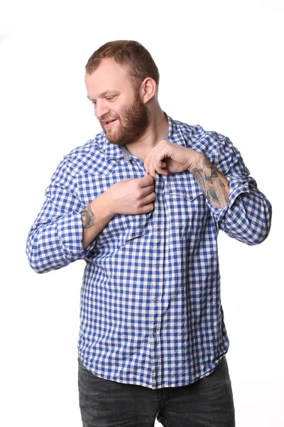 Young man with a beard, buttoning his shirt — 图库照片