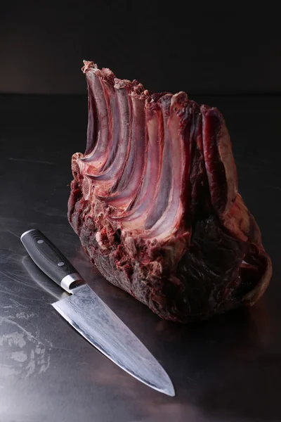 Syrové čerstvé jehněčí maso poblíž nůž na černém pozadí — Stock fotografie
