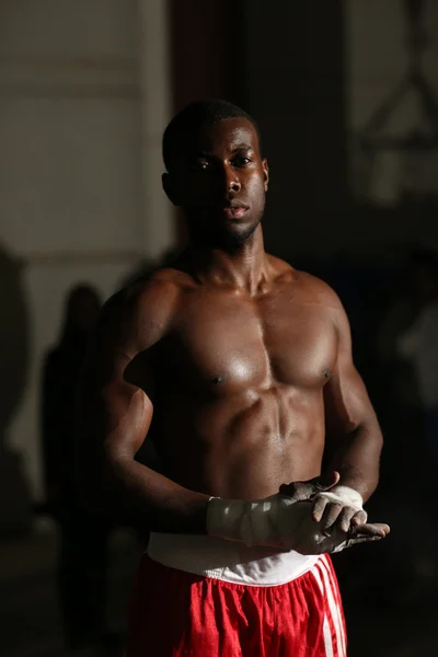 African American male boxer in red shorts at the gym