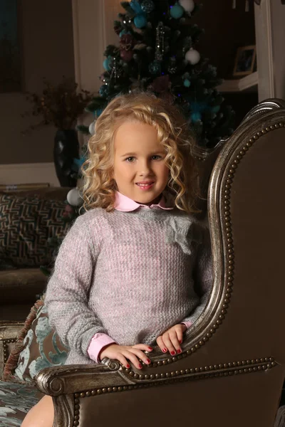 Söt liten blond flicka sittande peering över stol armar — Stockfoto
