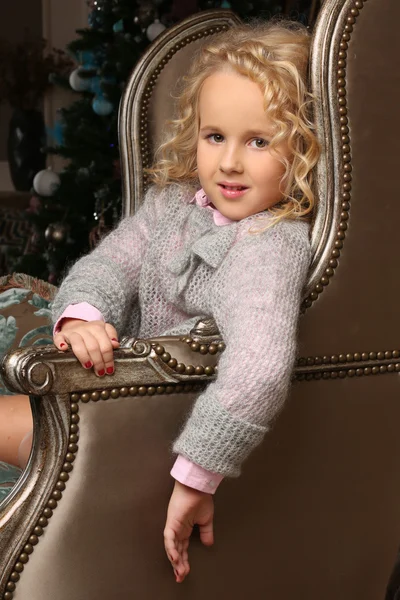 Симпатична маленька блондинка, що сидить, дивлячись на стілець — стокове фото