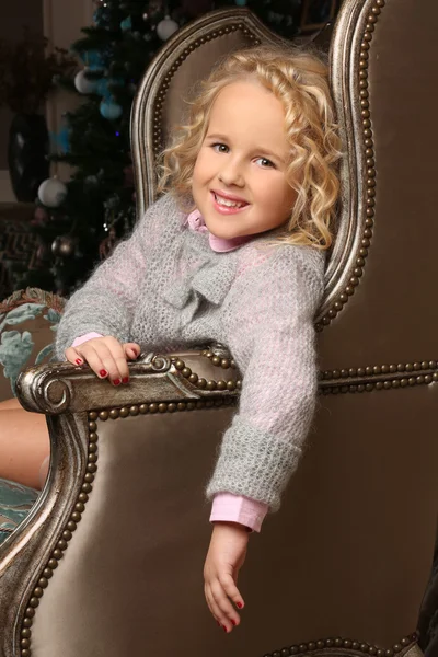 귀여운 작은 금발의 소녀 앉아 피어링 위에 의자 팔 — 스톡 사진