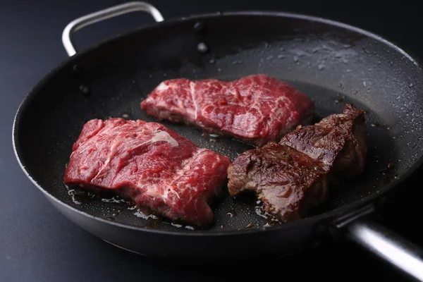 Verse ossenhaas biefstuk in koekenpan. Bkack backfround — Stockfoto