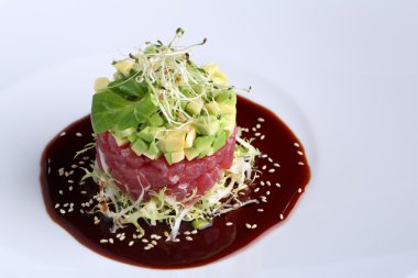 Füme somon, avokado, roka, mikrogreen ve kimyon beyaz plaka, koyu arka plan üzerinde soslu