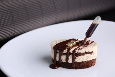 Beyaz plaka, koyu arka plan üzerinde krema ve çikolata ile Güvercinler süt lüzu