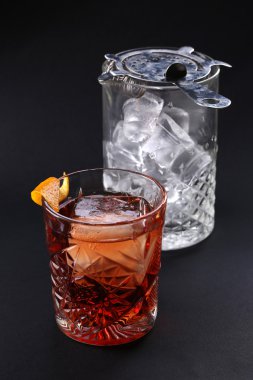 Siyah arka plan üzerinde buz ile cam yakınında eski moda Negroni kokteyl