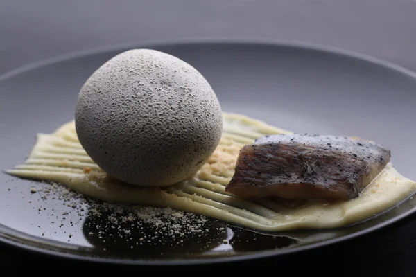 Bolas de patatas y pescado en arcilla servida sobre puré, fondo oscuro —  Fotos de Stock