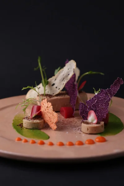 Pate with sauce, toast, jelly and arugula on a plate, closeup. Black background. Molecular cuisine — Stockfoto