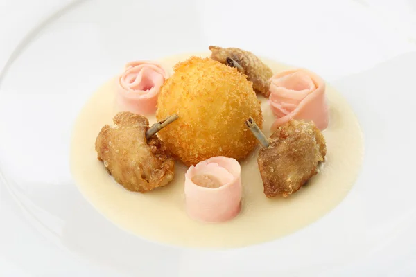 Bolas de pollo: bolas empanadas y fritas llenas de huevo y patas de pollo servidas con tocino, puré de apio en un plato blanco. De cerca. —  Fotos de Stock