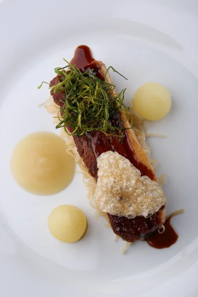 Filete de cerdo con manzana, verdura y salsa sobre fondo blanco. De cerca. —  Fotos de Stock