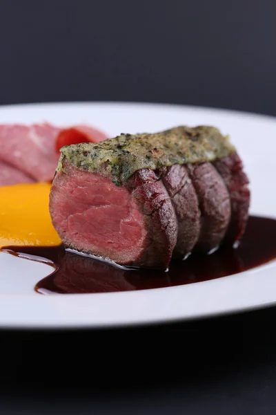 Delicious Meat Medallions with sauce on white plate, Isolated dark background — Stock Photo, Image