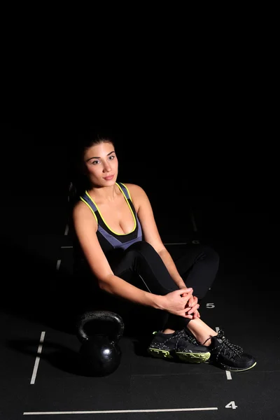 Söt ung Fitness kvinna, sitter med en Kettlebell — Stockfoto