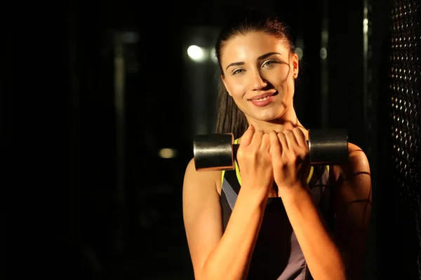 Porträtt leende Fitness flicka med hantlar i gymmet — Stockfoto