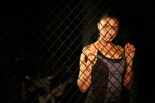 Портрет красивая фитнес-девушка у ограды сетки в тренажерном зале — стоковое фото
